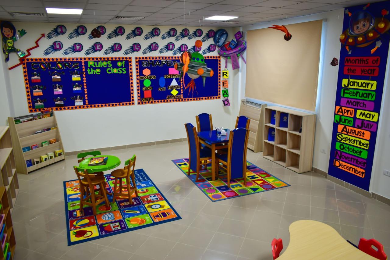 A vibrant and educational classroom interior designed for young children at IVY STEM International School. The room features educational decorations, small tables and chairs, colorful educational mats, shelves for storing materials, and playful decorative elements. This well-organized space stimulates learning and creativity among young students.